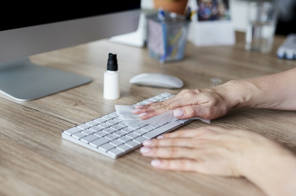 Woman cleaning keyboard in the office