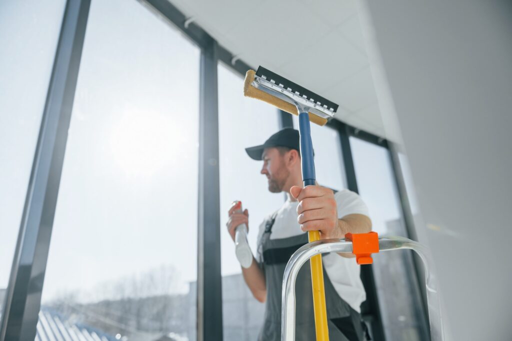 Cleaning services. Repairman is working indoors in the modern room